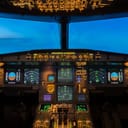 Close-up shot of the interior of a jet aircraft cockpit, during dawn.