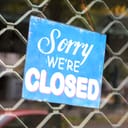 'Sorry we're closed' sign on the front door of a shop