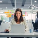 A female worker at an office using a laptop at desk