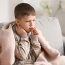Ill little boy with sore throat at home