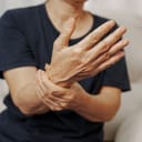 Close-up hands of an Asian senior woman with Parkinson's disease symptoms.