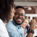 Smiling man wearing shirt and glasses at a meeting