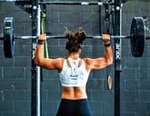 Woman doing an overhead press at the gym