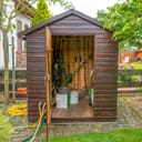 An open garden shed with tools inside