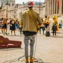 a street performer in London playing guitar and singing while the others are watching him