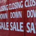 store displaying closing-down sale posters as it prepares to shut down
