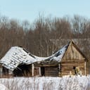 An old barn roof collapsed due to the weight of the snow