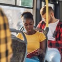 An African-American woman spends her morning on the bus.