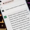 OpenAI's ChatGPT chatbot displayed on a smartphone resting on a laptop keyboard