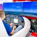 a young boy sitting in a flight simulator of a passenger aircraft