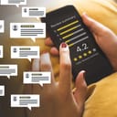 woman holding smartphone that's displaying consumer reviews with rating bubbles from customers' feedback