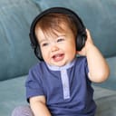 Adorable little baby boy listening to music in headphones.