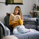 Woman reading a book on the sofa