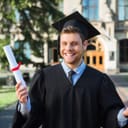 Smiling young man in black academic dress
