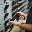 man holding a handgun in a gun shop