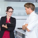 female inspector evaluating the restaurant kitchen alongside the chef
