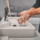 Woman washing her hands with soap and water