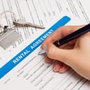 rental agreement form with signing hand and keys and pen