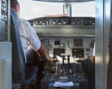 Interior of an airplane cockpit with two pilots present