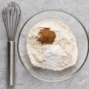 Whisker and a bowlful of flour, cinnamon and baking powder