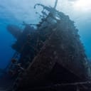close-up of the bow of a sunken ship lying on its side underwater