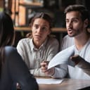 An upset couple talking with their legal representative while holding what seems to be a contract