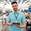 A salesman holding a tablet in an electronics store