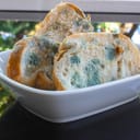 Three mouldy pieces of bread in a white ceramic bowl