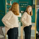 A young girl checking herself in the mirror