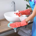 A woman cleaning a sink in the bathroom