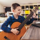 A young boy playing the classic guitar