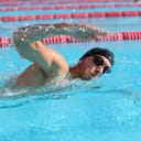 Man wearing professional gear swimming in a pool