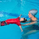 child learning to float during a swimming lesson