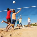 Children playing volleyball on the beach.