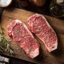 seasoned raw sirloin beef steak on cutting board