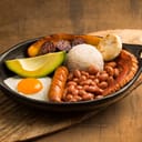 Colombian Bandeja Paisa from Antioquia region, served on a black plate.