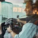 male truck driver checking the side mirror while reversing into a parking spot
