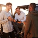Three male friends on a road trip using a tablet computer