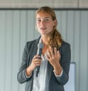 A sharply dressed young businesswoman giving a presentation. 