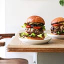 Two large hamburgers served on platters