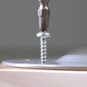 Closeup of a screw being secured into a surface