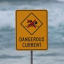 Sign reading "dangerous current" and signaling that swimming is forbidden