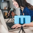 A young woman talking in a microphone while streaming herself online