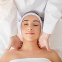 Close-up of a young woman enjoying a soothing shoulder massage from a skilled masseur at a luxury spa.