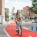 A young woman riding a bicycle down a bicycle lane