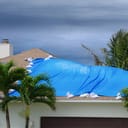 A blue tarp covering the damaged part of a roof