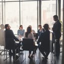 a group of business professionals engaged in a presentation during the meeting in a modern conference room