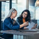 Two women amicably conversing at table