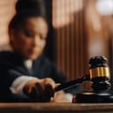 A judge hitting a gavel sound block with a gavel 