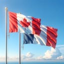 The Canadian flag and the French flag waving side by side against a clear blue sky.
